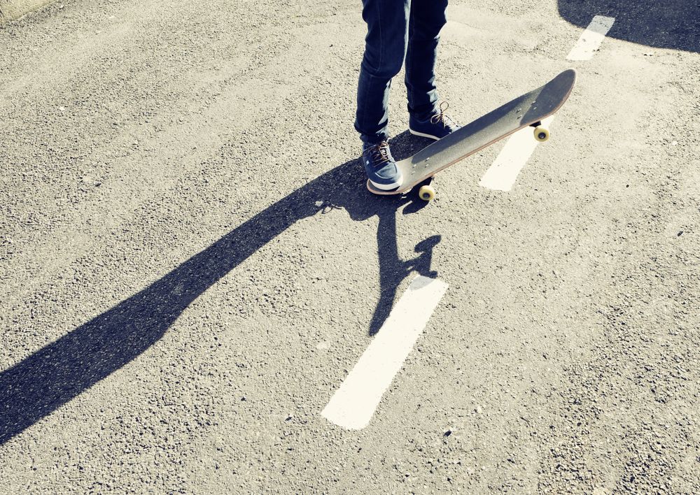 A person standing on a skateboard on a road