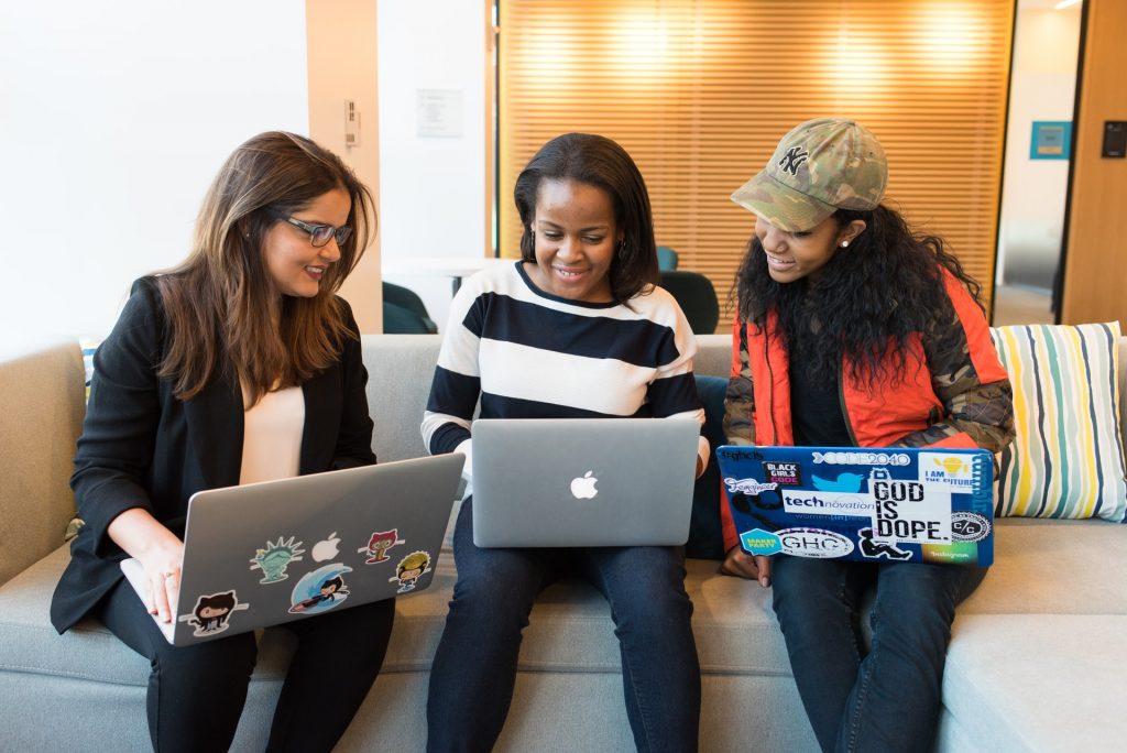 Three young women sitting with their computers