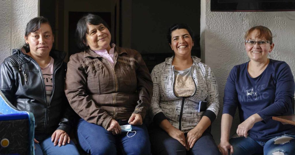 four women seated and smiling