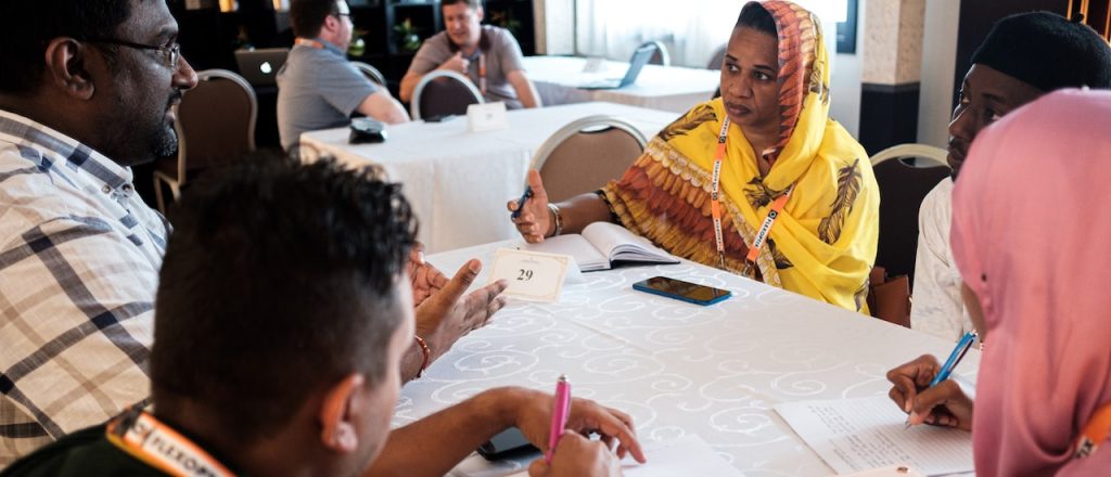 Delegates sit around a conference table