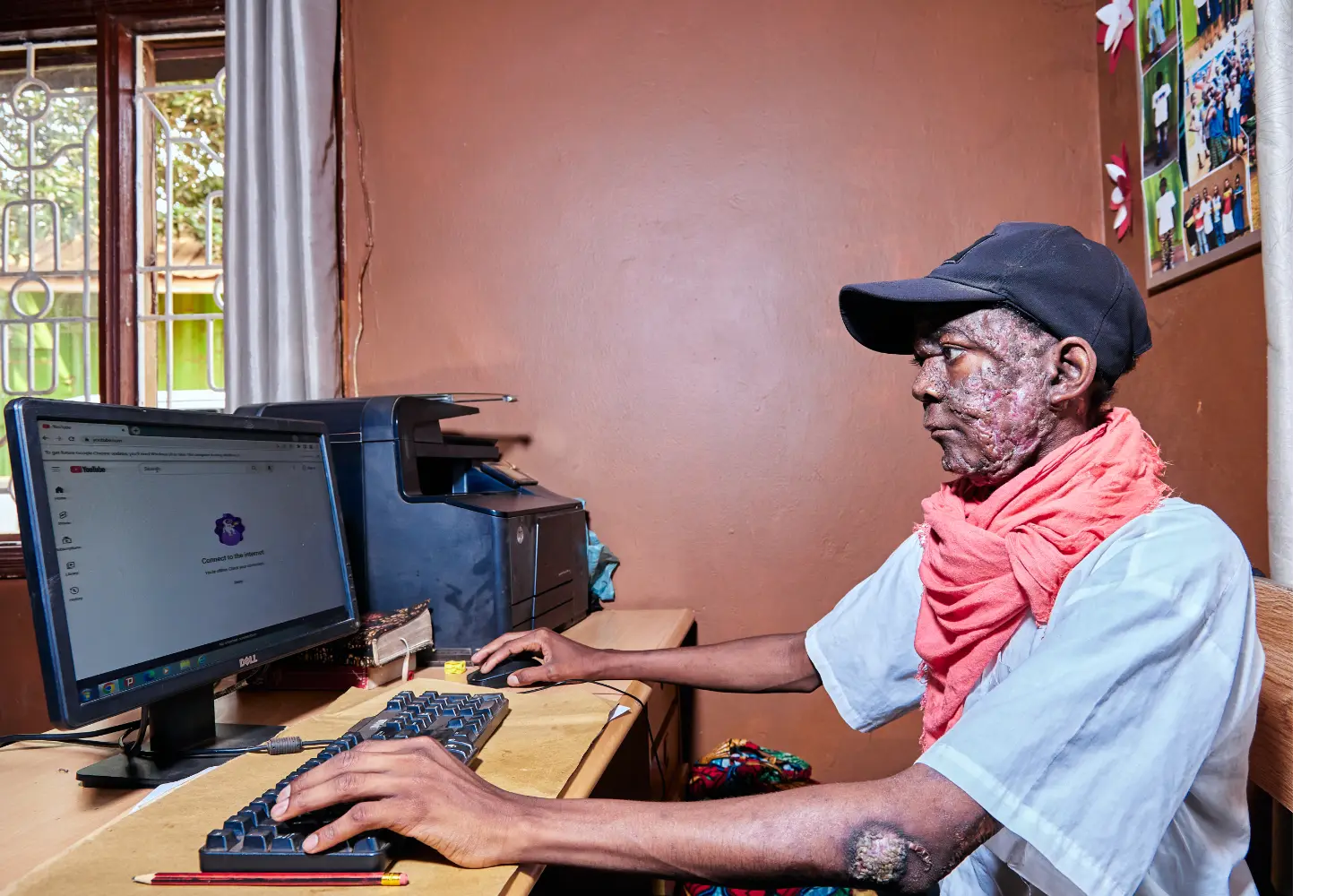 A man sits at a computer in a classroom