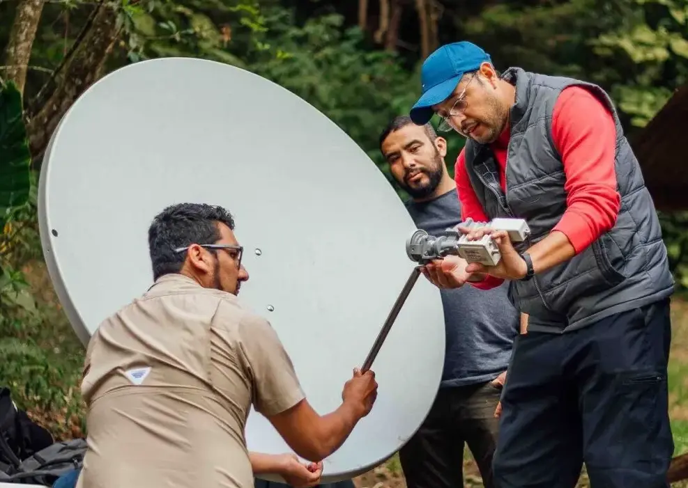 Two men set up a satellite dish