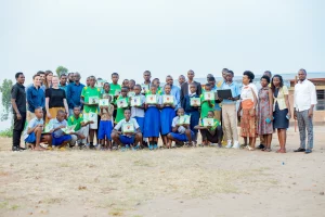 Rwandan students show their computers in a site visit from the Beyond The Net grant Program