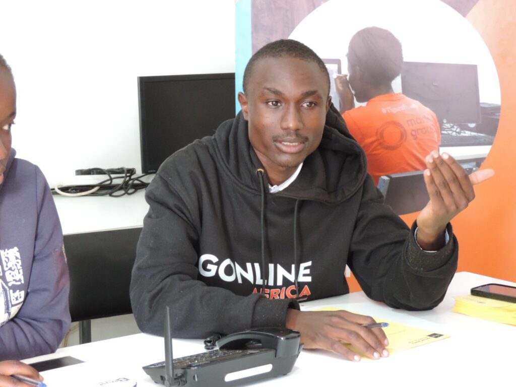 An african young man sitting in a computer class explaining his views