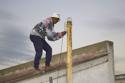 A man on a roof is assembling an Internet cable.