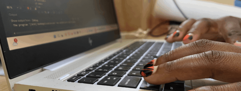 Hands typing on a laptop keyboard.