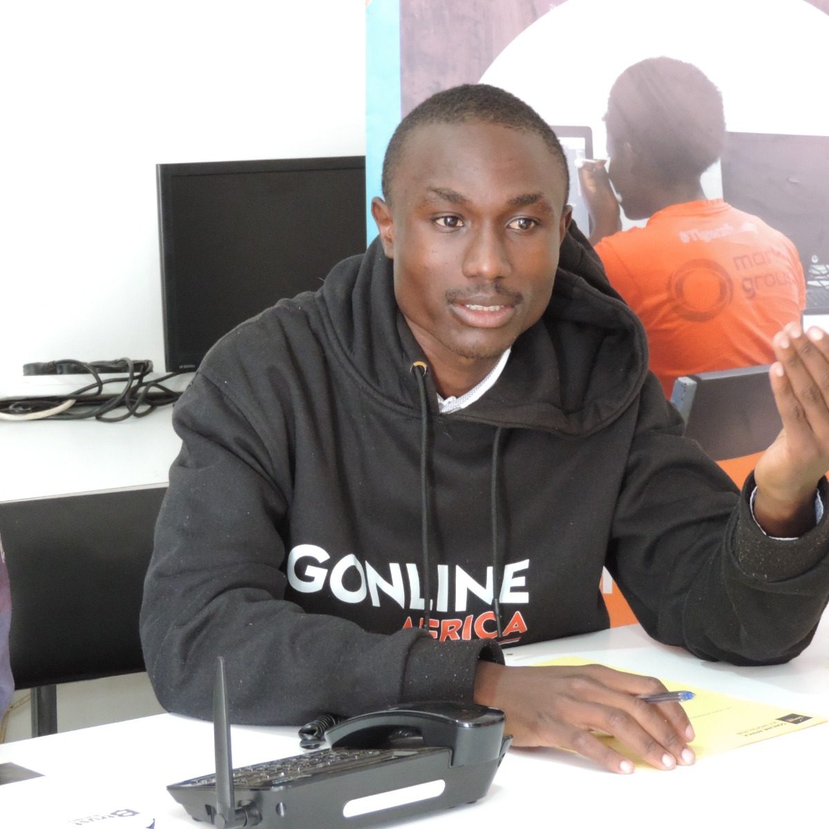 An african young man sitting in a computer class explaining his views
