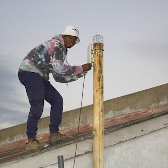 A man on a roof is assembling an Internet cable.