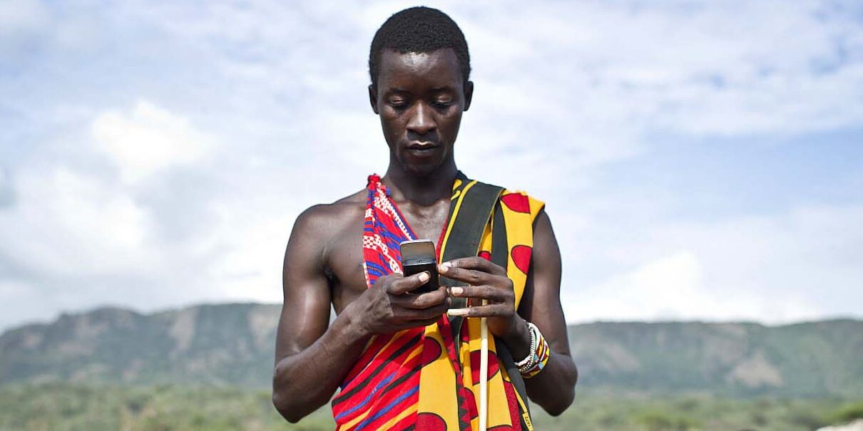 Isaac Mkalia, 20 years old, a teacher by profession is checking his mobil phone.